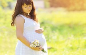 pregnant woman holding a bouquet of flowers