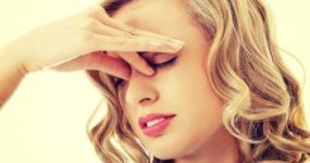 Woman with Vertigo Holding Bridge of Her Nose