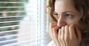 Woman Looking Out Window with Fear Facial Paralysis Atlanta GA 